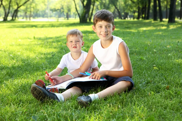 Children in the park reading a book — Stock Photo, Image