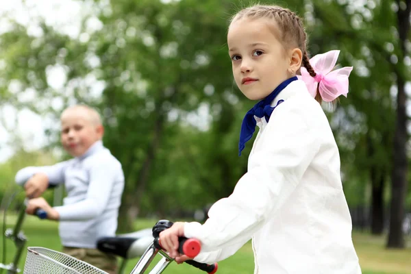 Девушка на велосипеде в зеленом парке — стоковое фото