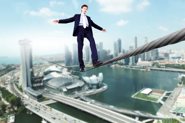 Бизнесмен балансирует на веревке — стоковое фото