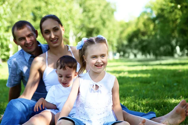 Family with two children in the summer park — Stok fotoğraf