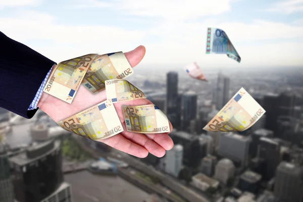 Panoráma města a ruce držící bankovky — Stock fotografie