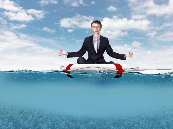 Businessman meditating on the rescue ring — Stock Photo, Image