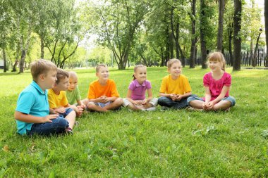 Grup birlikte parkta oturan çocuk