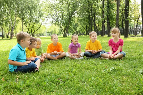Grup birlikte parkta oturan çocuk — Stok fotoğraf