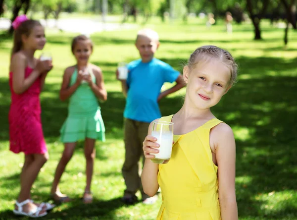 Menina bebendo leite no parque de verão — Fotografia de Stock
