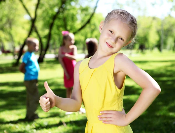 Маленькая девочка в летнем парке с друзьями — стоковое фото