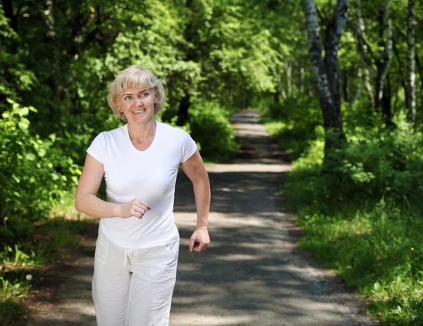 Femme âgée aime courir dans le parc — Photo