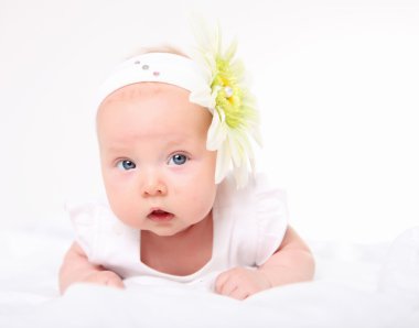 Portrait of a baby girl with a flower on her head clipart