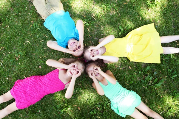 Children lying on the grass in the summer park — Stock Photo, Image