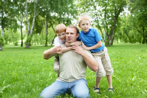 Porträt eines Vaters mit zwei Söhnen im Freien — Stockfoto