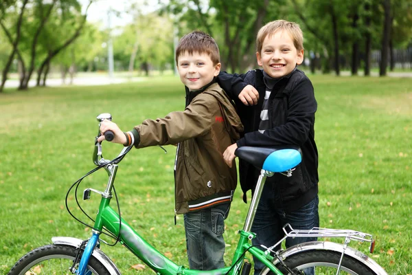 Yeşil parkta bisikletle evlat — Stok fotoğraf