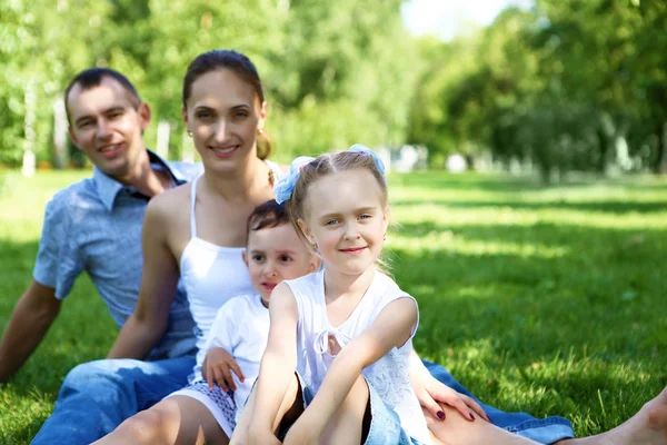 Сім'я з двома дітьми в літньому парку — стокове фото