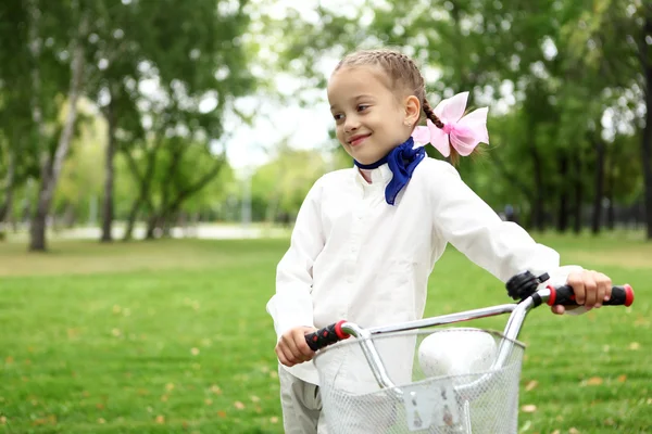 Chica en bicicleta en el parque verde — Foto de Stock