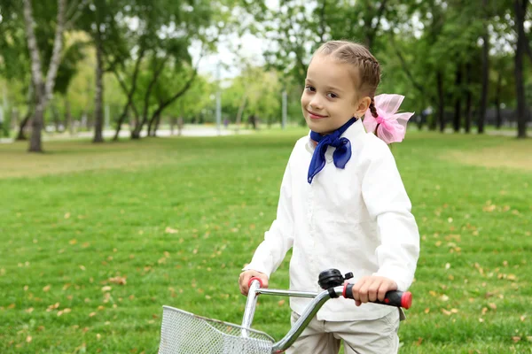 Дівчина на велосипеді в зеленому парку — стокове фото