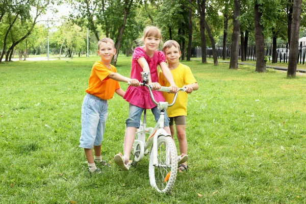 Flickor med en cykel i parken — Stockfoto
