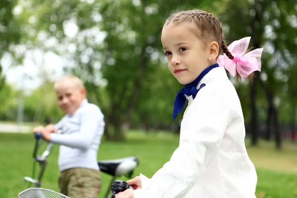 女孩骑着自行车在绿色公园 — 图库照片