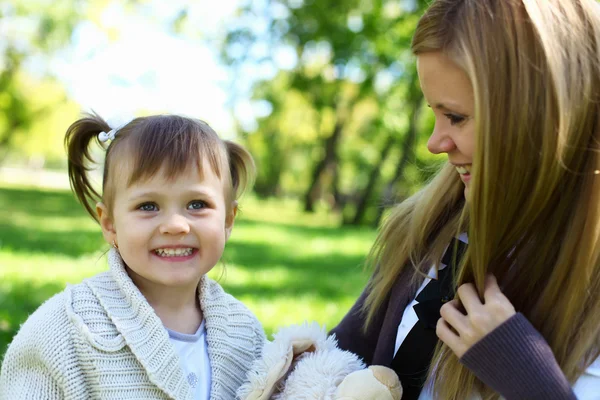 Kleines Mädchen spielt mit Mutter im Sommerpark — Stockfoto