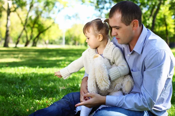 Young family with little daughter in summer park — Stock Photo, Image