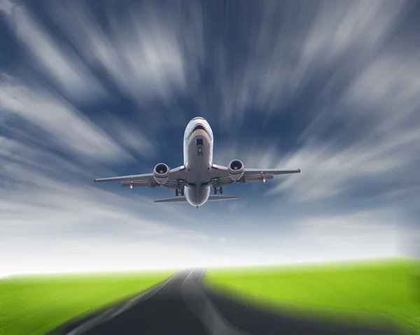 Lentokone sinisellä pilvisellä taivaalla — kuvapankkivalokuva