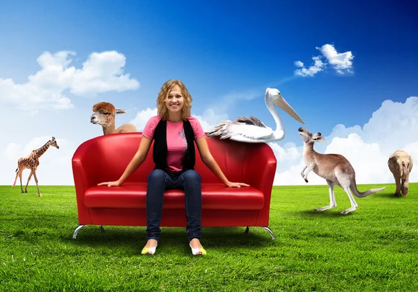 Mladá žena sedí na pohovce přírodní pozadí — Stock fotografie