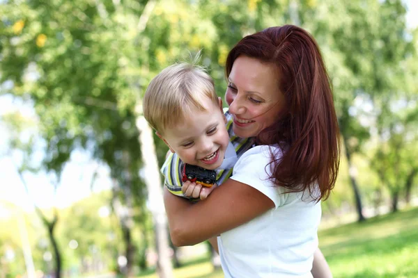 Νεαρή μητέρα με τον γιο της σε πάρκο καλοκαίρι — Φωτογραφία Αρχείου