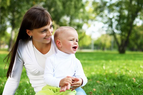 Young mother with her son in summer park Stock Photo