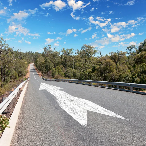 Empty countryside road with white arrow — Stock Photo, Image