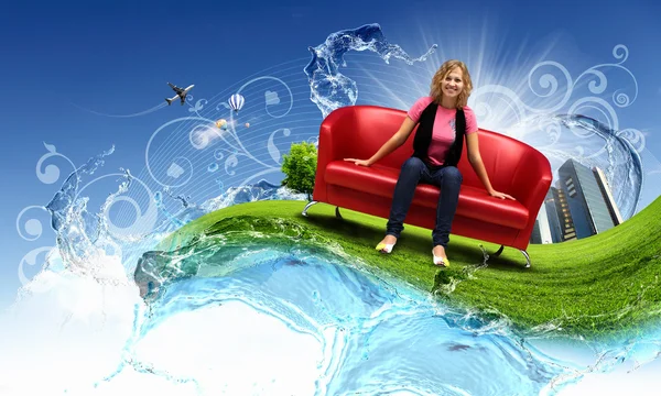 Jovem mulher sentada no sofá natureza fundo — Fotografia de Stock