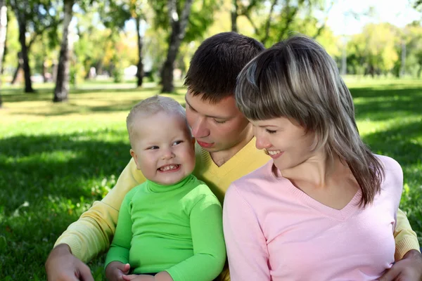 Familia joven con un niño en el parque de verano — Foto de Stock