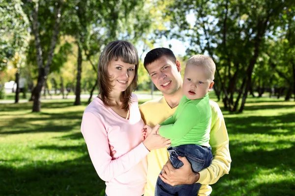 Familia joven con un niño en el parque de verano —  Fotos de Stock