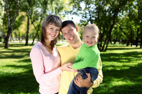 Młode rodziny z dzieckiem w lato park — Zdjęcie stockowe
