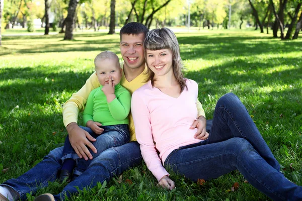Jeune famille avec un enfant dans un parc d'été — Photo