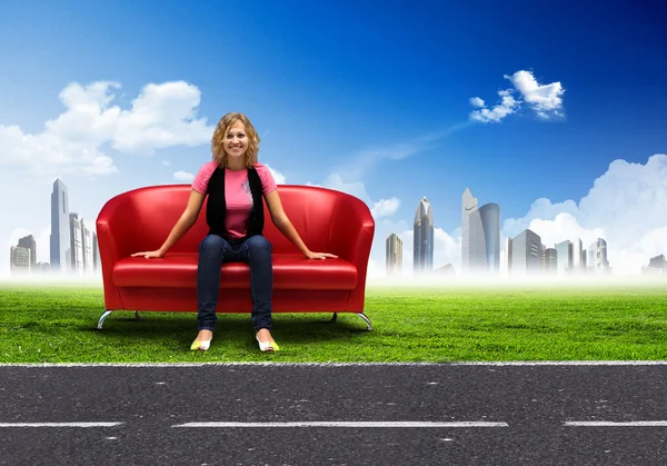 Young woman sitting on sofa nature background — Stock Photo, Image