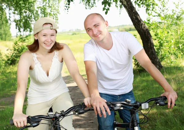 Young couple on the bikes in the park — Stock Photo, Image
