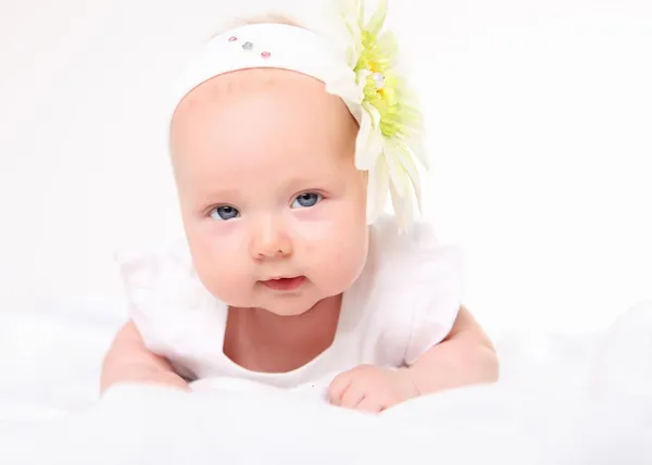 Portrait of a baby girl with a flower on her head — Stock Photo, Image