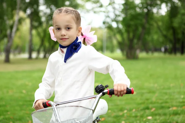 Flicka på en cykel i den gröna parken — Stockfoto