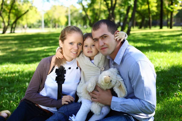 Família jovem com filha pequena no parque de verão — Fotografia de Stock