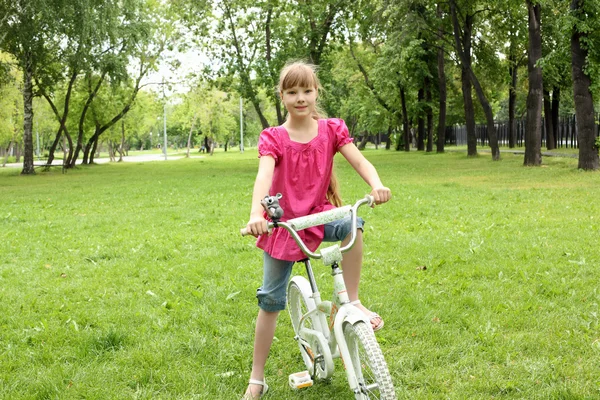Дівчина з велосипедом у парку — стокове фото