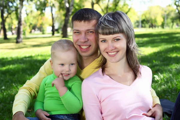 Junge Familie mit Kind im Sommerpark — Stockfoto