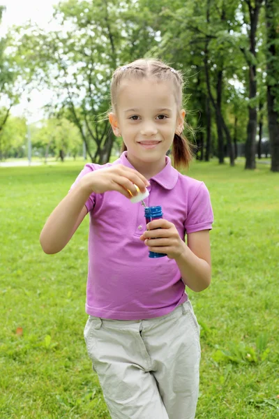 Bambina nel parco che soffia bolle — Foto Stock