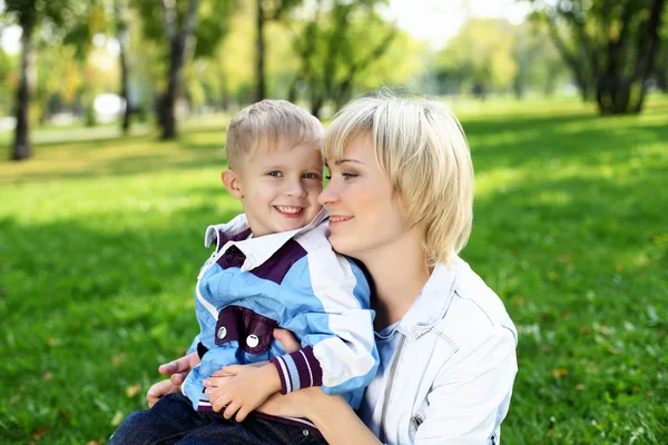 Jovem mãe com seu filho no parque de verão — Fotografia de Stock