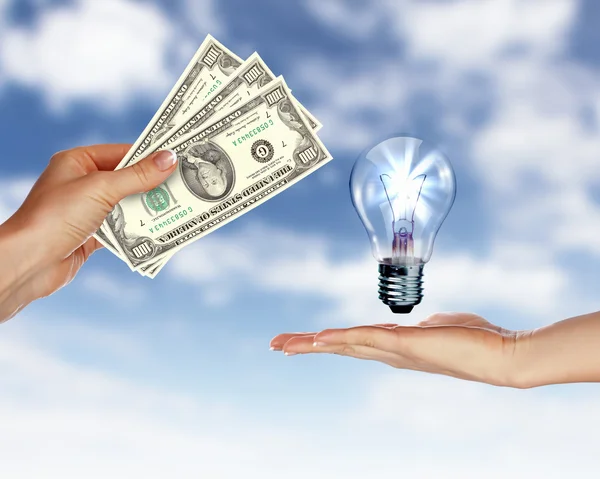 Mänskliga händer med pengar och elektrisk lampa — Stockfoto