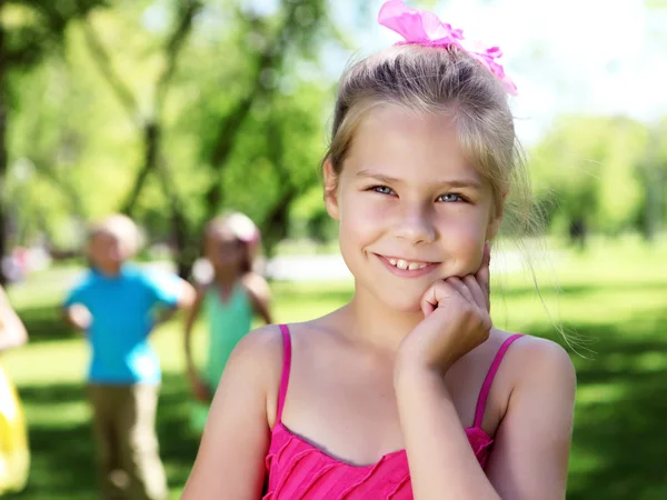 Malá holčička v letním parku s přáteli — Stock fotografie