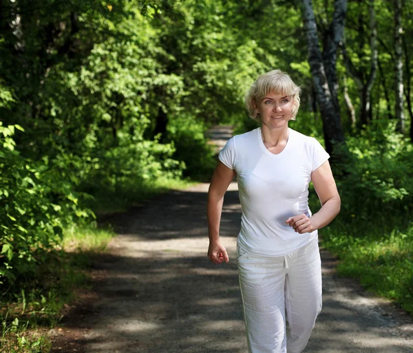Starší žena se rád běžet v parku — Stock fotografie