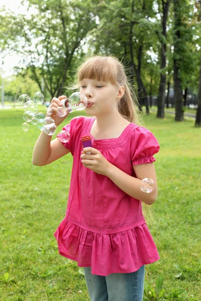 Gadis kecil di taman meniup gelembung — Stok Foto