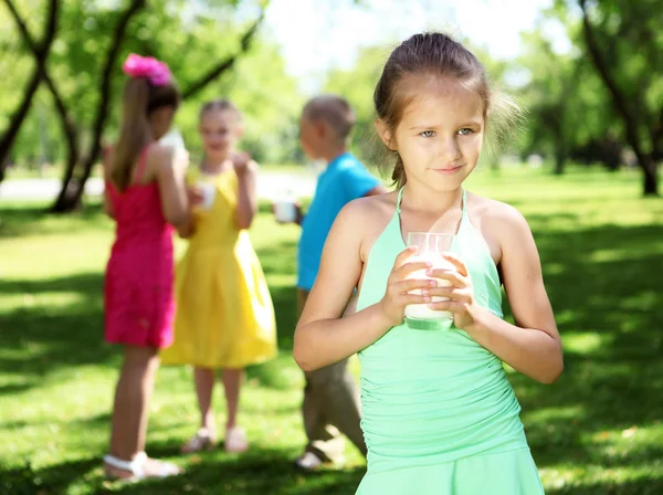 Girl drinking milk in the summer park — Stock Photo, Image