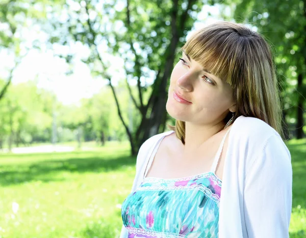 Ung kvinna avkopplande i parken sommaren — Stockfoto