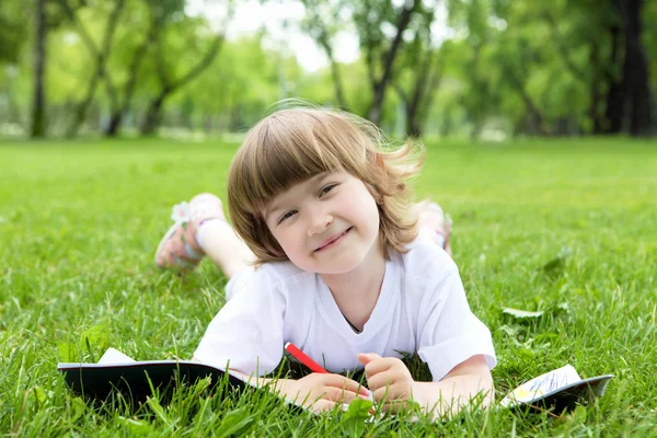 Portrait of little girl reading a book in the park Royalty Free Stock Photos
