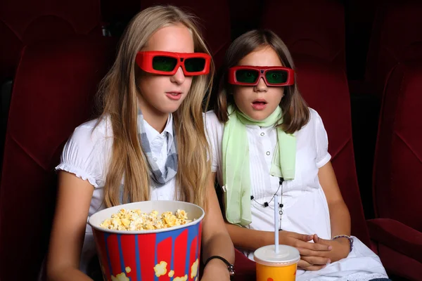 Dos chicas jóvenes mirando en el cine Fotos De Stock