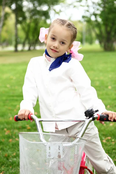 Κορίτσι σε ένα ποδήλατο στο πράσινο πάρκο — Φωτογραφία Αρχείου